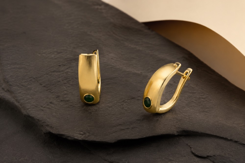 Bodegón de joyería: aretes sobre superficie