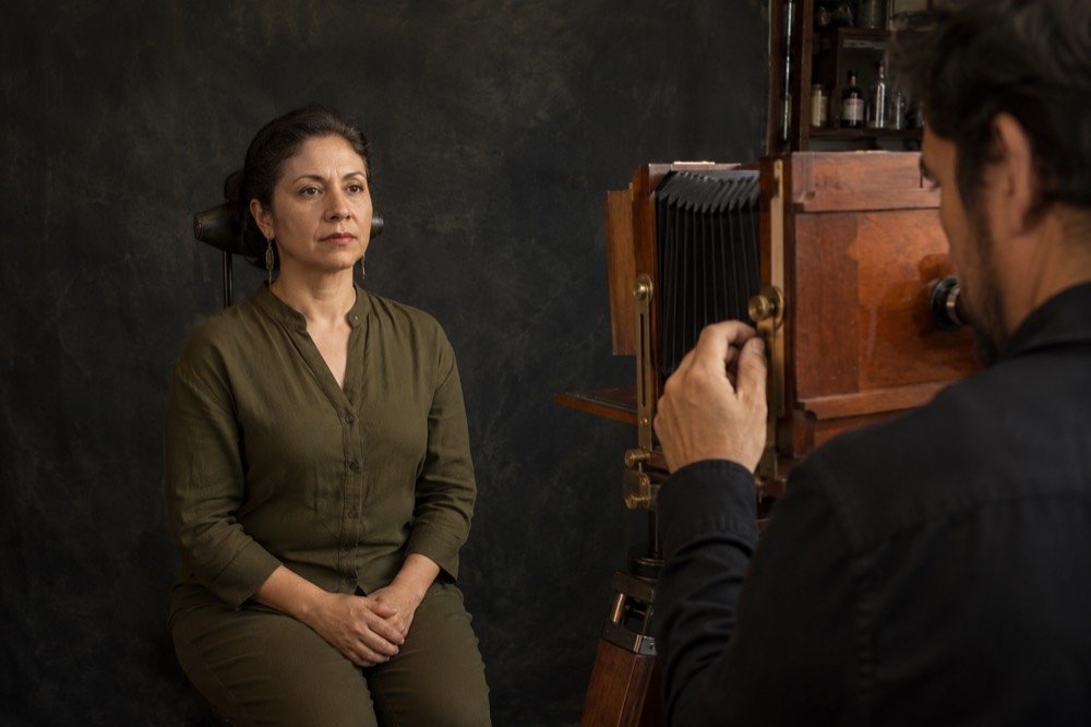 Persona sentada frente a una cámara de gran formato en el atelier